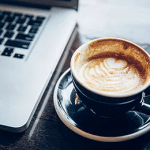 Coffee cup and computer to illustrate how outsourcing your SEO can help you relax knowing your website will soon rank well on Google.