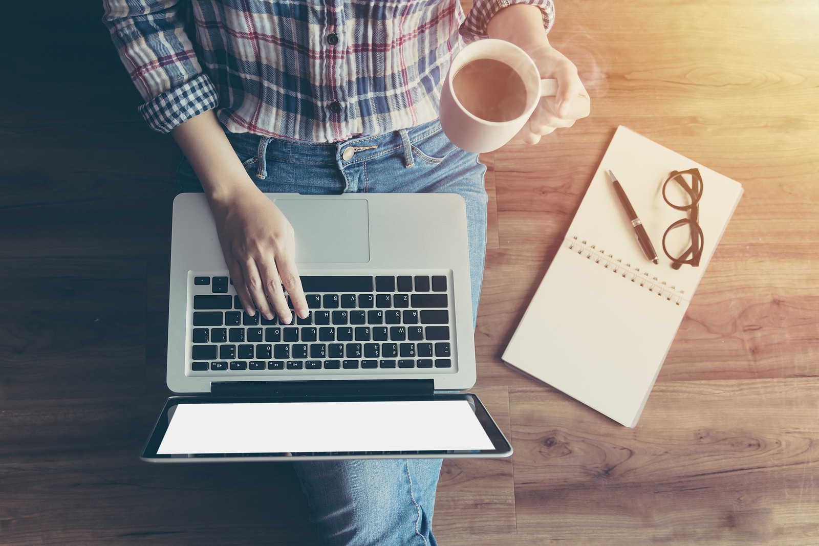 woman at laptop drinking a cup of coffee working on her private practice's website. Begin SEO services with Simplified SEO consulting