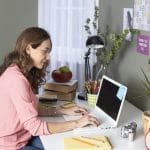female therapist works in her at home office writing blogs after researching seo keywords that her ideal clients are looking for. She learns tips from members of the Simplified SEO consulting staff