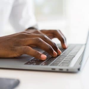 Photo of hands typing on a keyboard representing a therapist, psychiatrist or counselor optimizing their private practice website to reach more people in their niche or specialty.