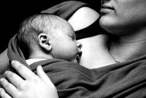 Photo of baby sleeping close to mother. Represents how our SEO Services for midwives and doulas allow them to help more new moms.