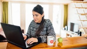 Pretty woman in a sweater works on SEO for online therapy website after getting SEO services with Simplified SEO consulting