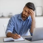 middle age man at his computer looks frustrated writing content for SEO. He gets tips on readability and writing content for his private practice from SEO specialist at Simplified SEO Consulting