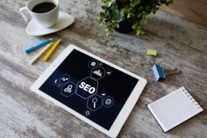 A tablet rests on a table with the word SEO and multiple graphics. Learn about our off page seo checklist, and how to we can help with off page optimization. 