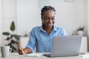 Attractive Black female clinician working on her computer representing SEO for counselors. Learn 5 quick tips to optimize your website from an SEO specialist at Simplified SEO Consulting