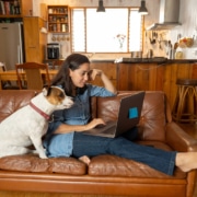 woman with her dog writes on a computer representing copywriting for SEO. Learn more about SEO for therapists from an SEO specialist at Simplified SEO Consulting