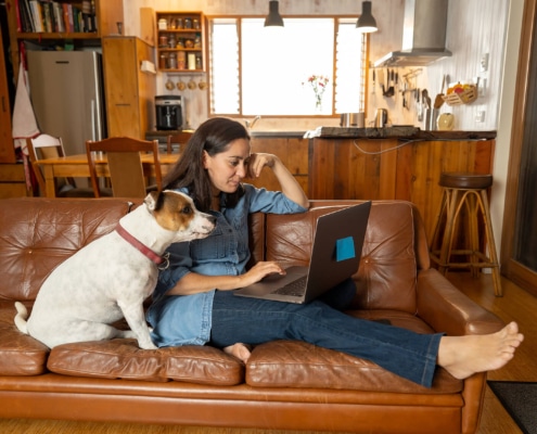 woman with her dog writes on a computer representing copywriting for SEO. Learn more about SEO for therapists from an SEO specialist at Simplified SEO Consulting
