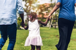 Parents holding young black girls hands outside. Needing support with seo for therapists. Ready to reach out and support your community? Learn about effective marketing strategies for Africans Americans and the black community.