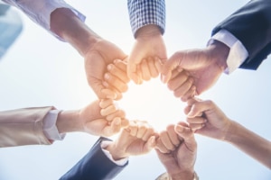 Image of multiple hands fist bumping representing the teamwork needed to boost your backlinks for therapists on your website. Learn more about backlinks for therapists at Simplified SEO Consulting today!