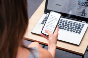 Image of someone scrolling on their phone and computer. This image depicts how a therapist can hire an SEO consultant for help on their private practice website. 