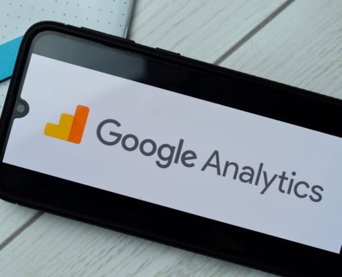 A close up of a phone with the logo for google analytics. Simplified SEO Consulting can offer support with Google Analytics in Counseling. Learn more about how to rank on google for counselors today! 65202