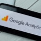 A close up of a phone with the logo for google analytics. Simplified SEO Consulting can offer support with Google Analytics for personal injury lawyers. Contact us today to learn more SEO techniques for law firms.