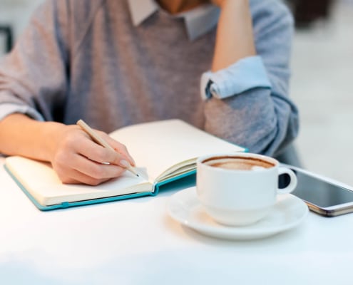 Image of a professional woman writing in a notebook. Represents how story brand can help SEO