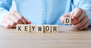 Photo of a man putting the word keyword together with lettered blocks. This photo represents the importance of using SEO keywords for therapists to rank higher on Google