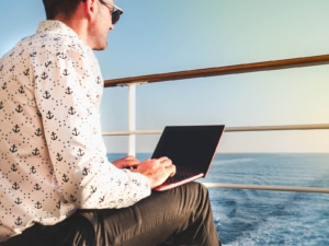 Man on boat typing. Are you in the midst of the summer slowdown in Chicago, New York, California, or Montreal? SEO for therapists can help. This is the best time to optimize your private practice website. Learn more!