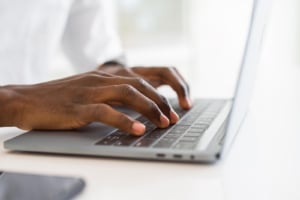 Photo of a person typing on a computer representing how therapists can learn SEO online to improve the rankings of their private practice website.