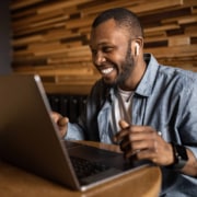 Shows a man smiling at the computer. Represents how simplified seo consulting can help with blogging and content