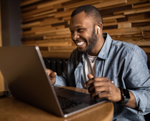Shows a man smiling at the computer. Represents how simplified seo consulting can help with blogging and content