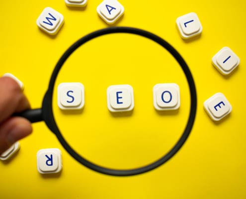 A hand holds a magnifying glass over the words SEO. Having trouble understanding SEO in healthcare? Our team of specialists can help you understand healthcare SEO and how to implement it.