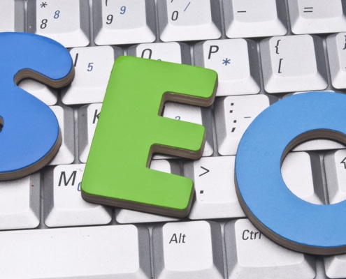The letters SEO in blue and green laying on a keyboard. Want to learn how to use SEO tools for your business? Our team of SEO specialists can teach you SEO basics.