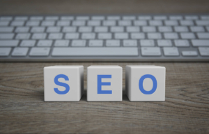 Photo of white blocks in front of a keyboard that spells out SEO. This photo represents how important SEO consulting is to a website and how SEO specialists can help you.