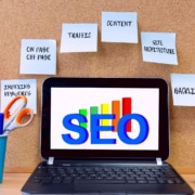 Shows a computer with the word "SEO" with components of it on sticky notes. Represents how seo for private practices can improve with SEO friendly content.