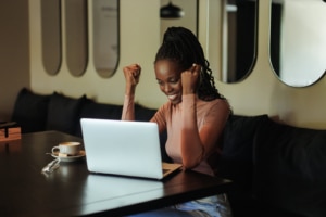 Image of a happy woman at the computer celebrating. You too could celebrate the support that you'll start getting if you sign up with us today. SEO for therapists doesnt have to be confusing, let us help! 