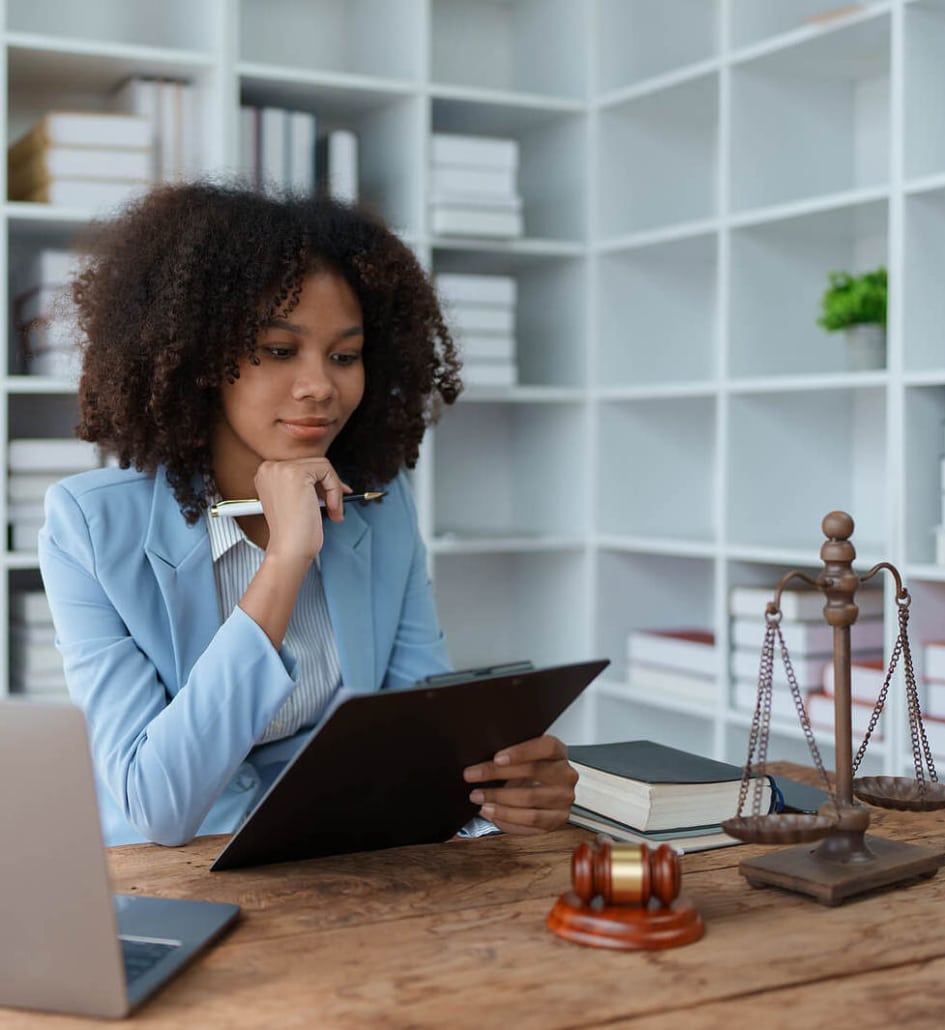 An individual sitting at a desk reviewing paperwork. SEO for personal injury lawyers is beneficial for reaching your ideal clients. Learn more here.