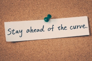 Shows a piece of paper saying "Stay ahead of the curve" with a thumbtack holding it up. Represents how SEO and storybrand can help therapist seo stay ahead of changes.