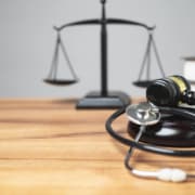 A stethoscope & justice scale on a desk. Unlock your law firms hidden potential with SEO services! Law firm SEO can help you grow.