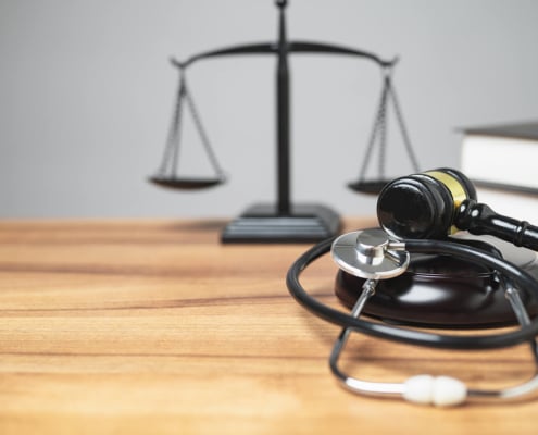 A stethoscope & justice scale on a desk. Unlock your law firms hidden potential with SEO services! Law firm SEO can help you grow.