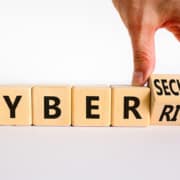 Cyber Risk on wooden blocks. If you are interested in learning more about password protection and scams, contact us today!