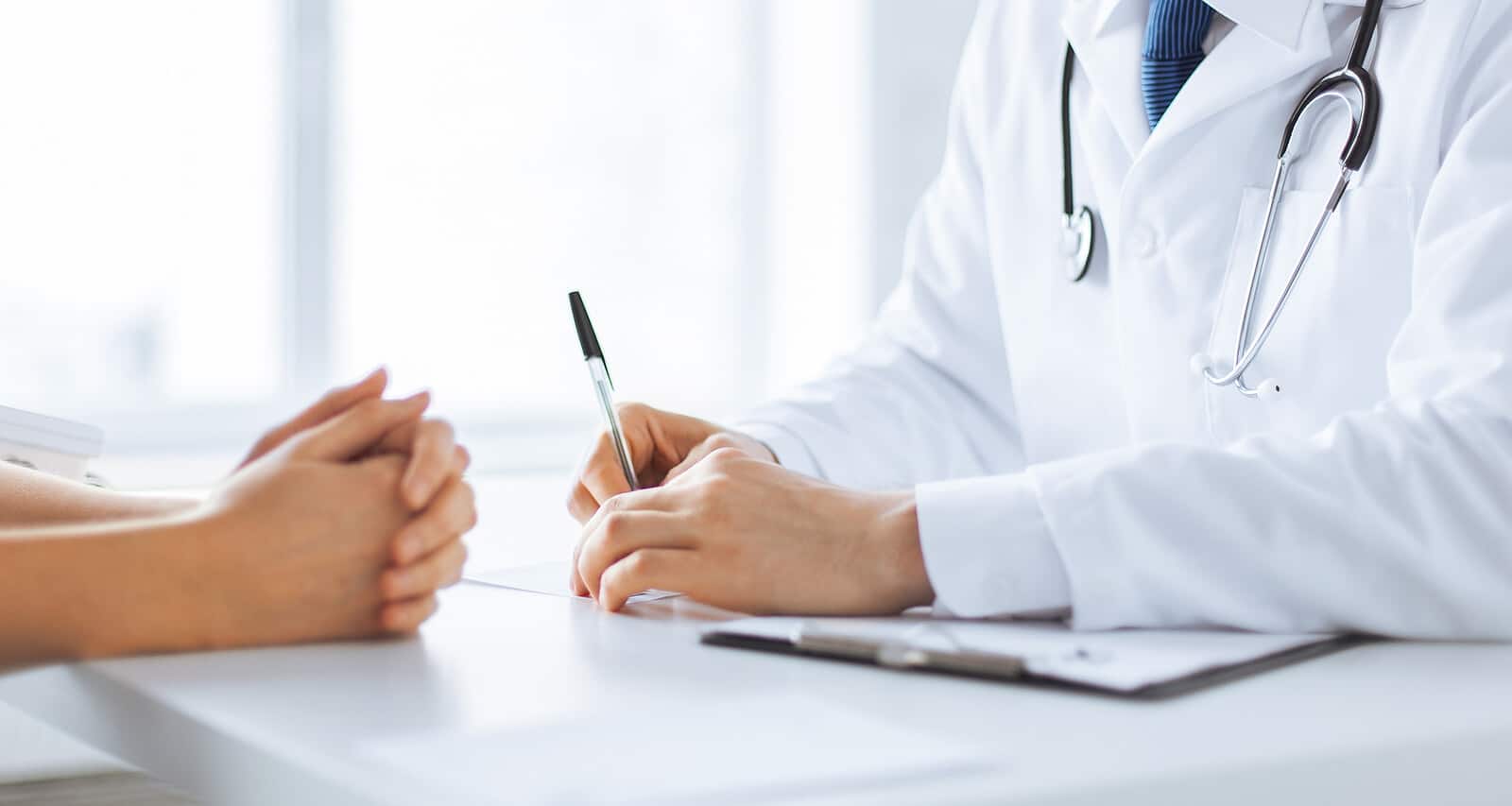 A doctor sits with a patient at a desk. Are you looking for SEO success for functional medicine doctors? We can help you maximize on your healthcare SEO keywords and healthcare SEO strategies today!