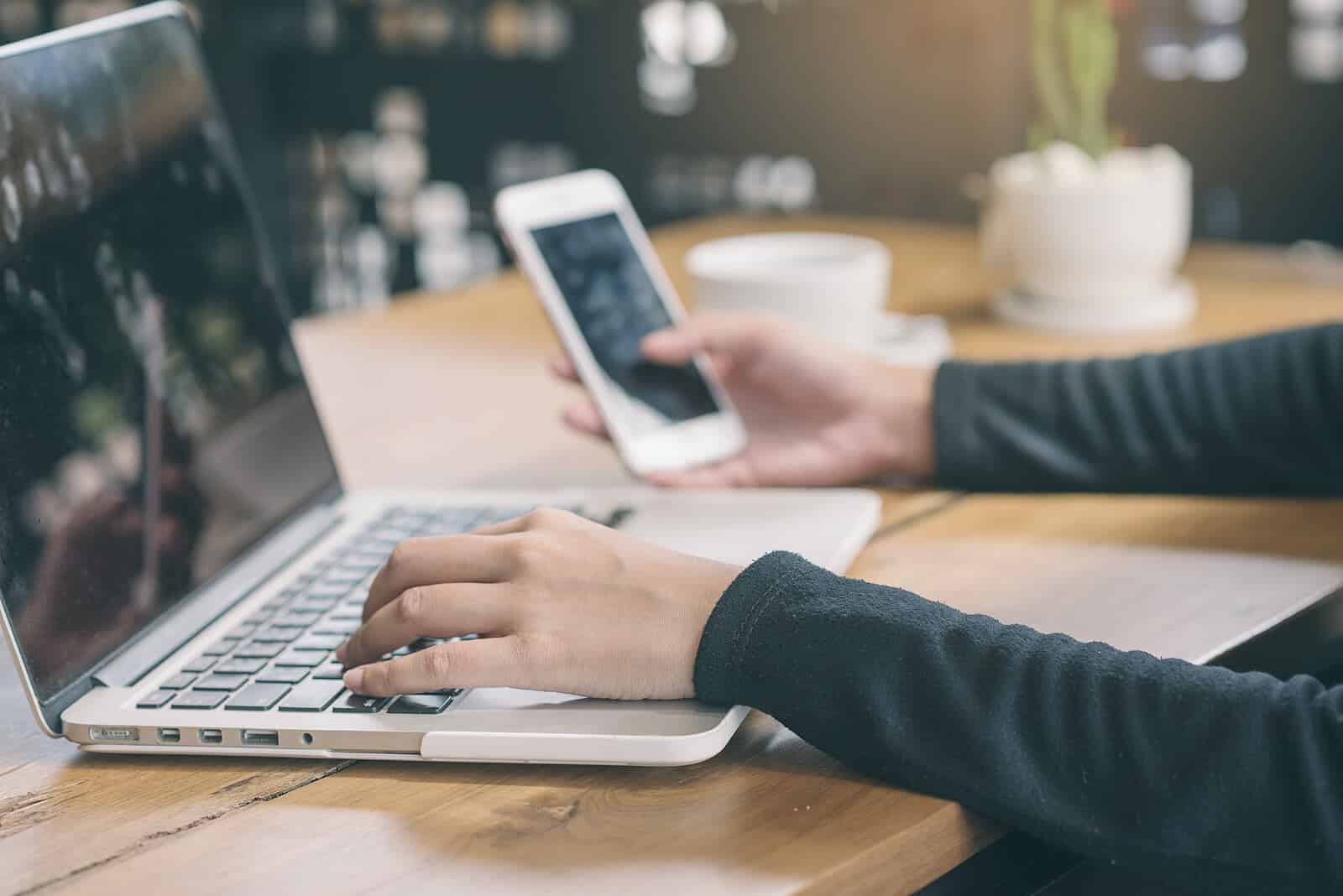 A person uses their laptop and phone at the same time. Want to learn how to create good SEO content? Our team can help you grow your SEO strategy for your practice.