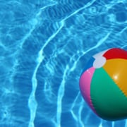 A beach ball sitting in a pool. Build ethical backlinks this summer by reading our blog here. Start your SEO journey today!