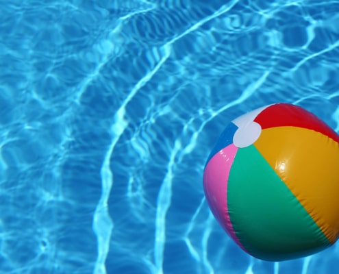 A beach ball sitting in a pool. Build ethical backlinks this summer by reading our blog here. Start your SEO journey today!