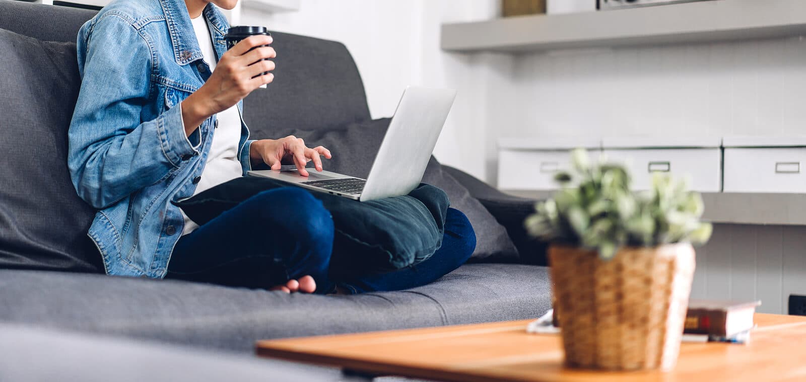 A woman sits on her couch with a laptop and coffee. Want to learn how mental health therapy keywords can make a difference to your practice? See how an SEO specialist can help you today.