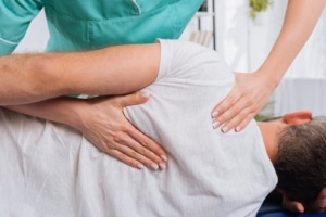 A chiropractor working on an individual wearing a white shirt, laying down. Our SEO for functional medicine can help you get your website ranking higher on Google. Reach out today to get started!