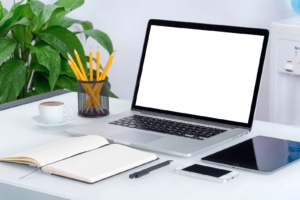 A blank laptop screen open on a desk sitting near a notebook & other technology. Discover how our SEO for functional medicine doctors can help your website reach the 1st page of Google. Reach out today to learn more. 
