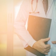Physician standing with a clipboard and stethoscope. Grow your practice and attract the right patients using seo for functional medicine doctors and expert strategies.
