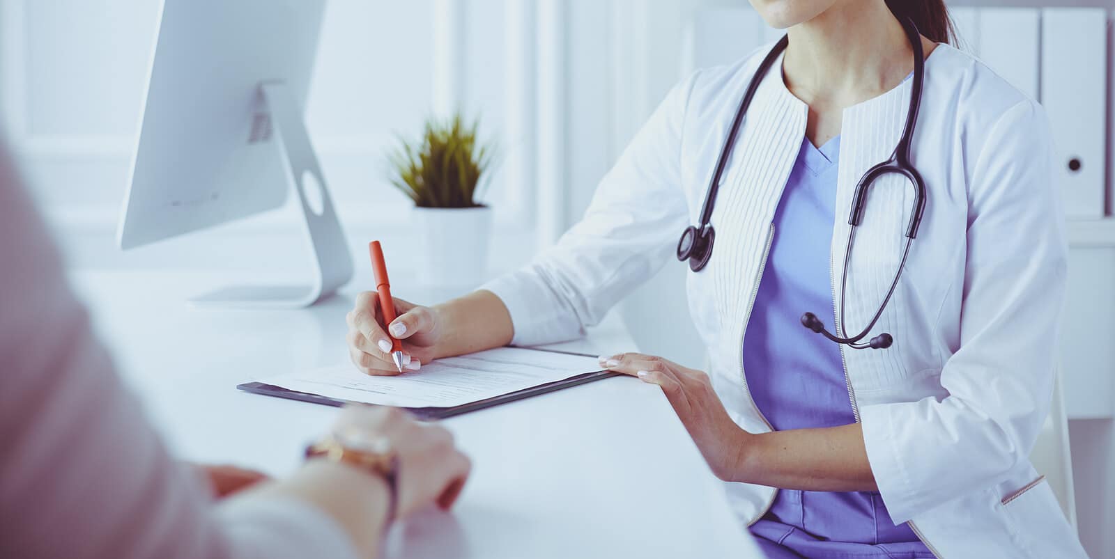doctor writing notes | functional medicine seo | seo for holistic health and wellbeing | seo for functional medicine doctors | Arkansas | Minnesota | North Carolina Female doctor filling out medical forms during a consultation. Boost patient trust and visibility through functional medicine SEO with Simplified SEO Consulting.