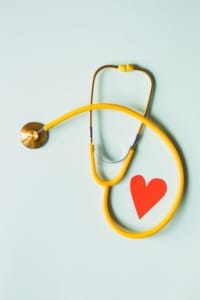 A yellow stethoscope arranged in the shape of a heart on a light background, symbolizing healthcare and patient trust. Local SEO for doctors, Local SEO doctors marketing, and SEO for doctors all work together to help medical professionals connect with patients online. 