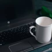 White coffee mug resting on a laptop, representing how holistic health providers use digital tools and SEO for holistic health and wellbeing to reach new clients in 2025.
