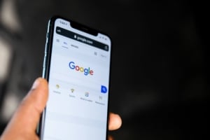 Person holding a smartphone with the Google search page open, emphasizing the importance of local SEO for medical professionals and the value of a medical practices SEO consultant in enhancing online visibility."