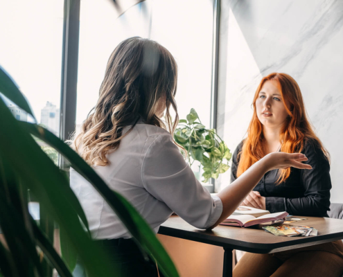 Holistic practitioner talking with a client in a bright office, representing how local seo for therapists and seo for mental health can help caring professionals fill their caseloads. This scene also reflects private practice seo and local seo for medical professionals supporting real conversations and healing.