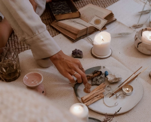 A person arranging crystals, candles, and spiritual tools on a mat during a calming, holistic ritual. Find your aligned clients and grow your SEO rankings with the support of Simplified SEO Consulting.