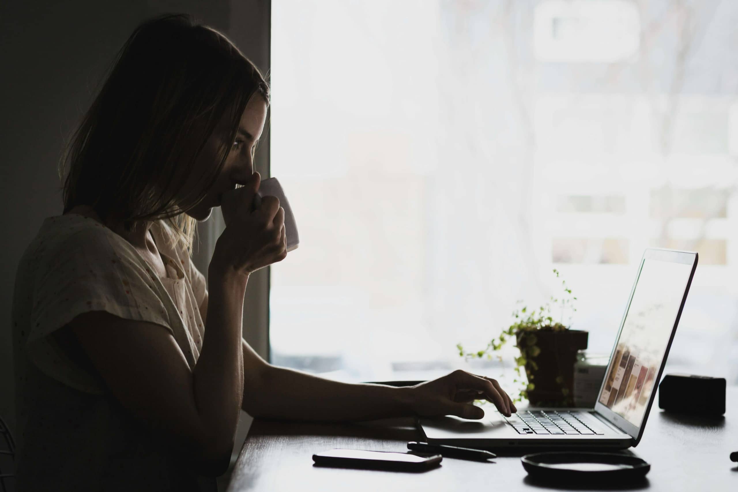 A woman sips coffee while working on a laptop. When therapy practices struggle with online visibility, where should you start? SEO for therapists prioritizes foundational elements like website structure, content quality, and consistent local optimization.