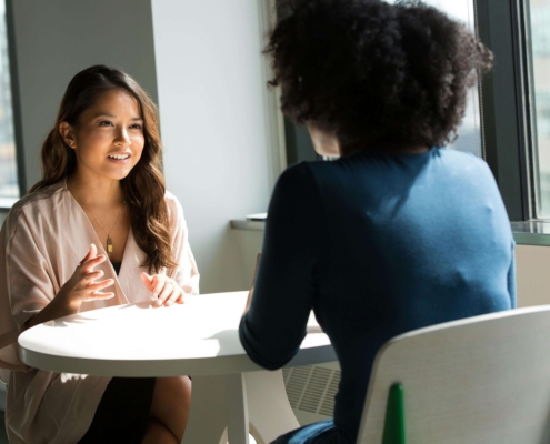 Alternative healer speaking with a client in a calm office setting, showing how alternative healing SEO connects practitioners with the right audience.