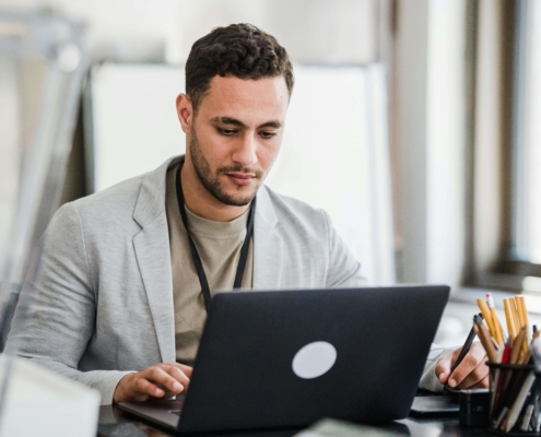 Alternative healer researching alternative healing SEO strategies on laptop while considering hiring a local SEO consultant to grow their wellness practice