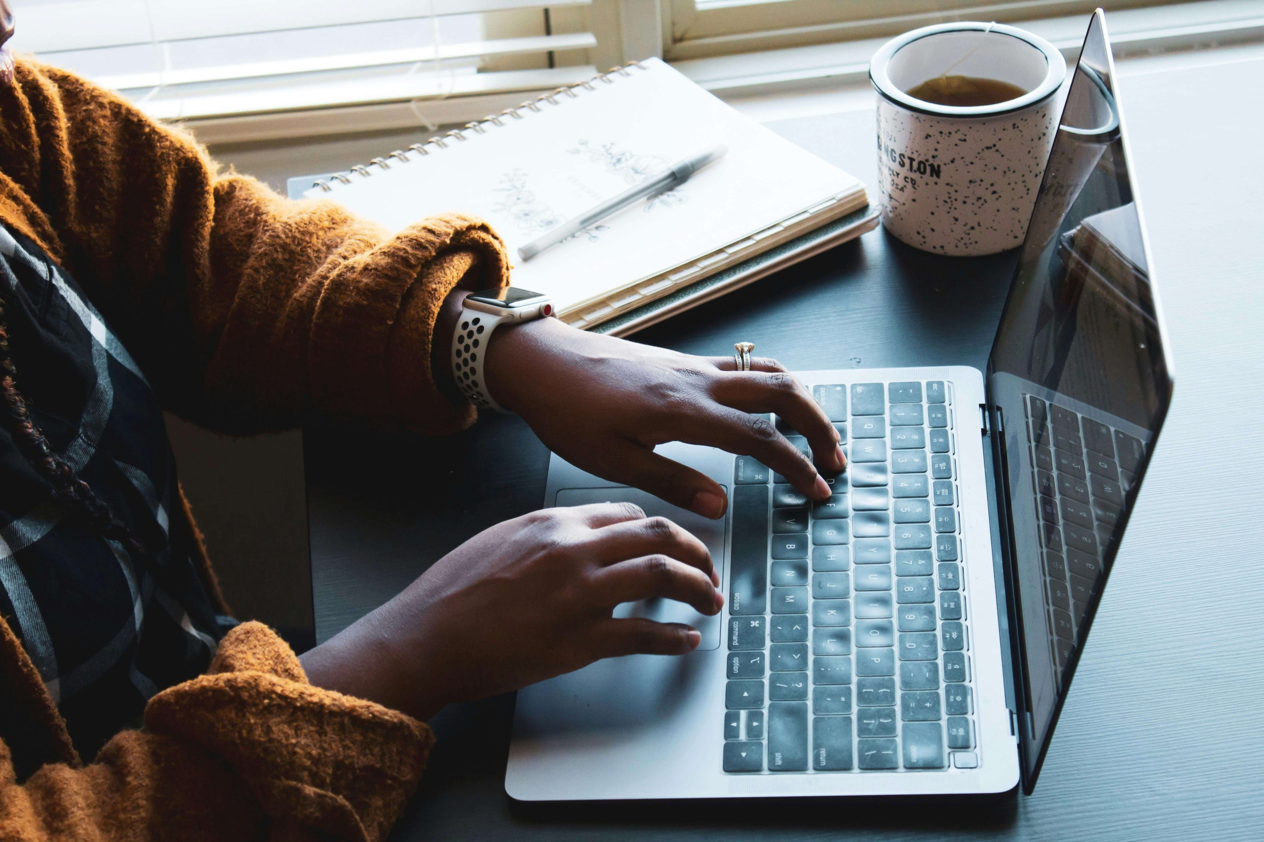A woman’s hands type on a laptop beside a coffee mug and notebooks on a desk. Does search engine optimization feel overwhelming for your therapy practice? SEO services for therapists focus on sustainable strategies that build visibility over time, not quick fixes.